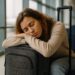 Persona agotada por jet lag dormida sobre su maleta en sala de espera del aeropuerto