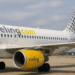 Avión de Vueling Airbus A320 con motor amarillo y cola con puntos, estacionado en el aeropuerto
