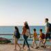 Familia viajando con niños por un paseo marítimo frente al mar durante sus vacaciones