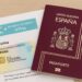Pasaporte español junto a DNI y visado electrónico sobre mesa de viaje