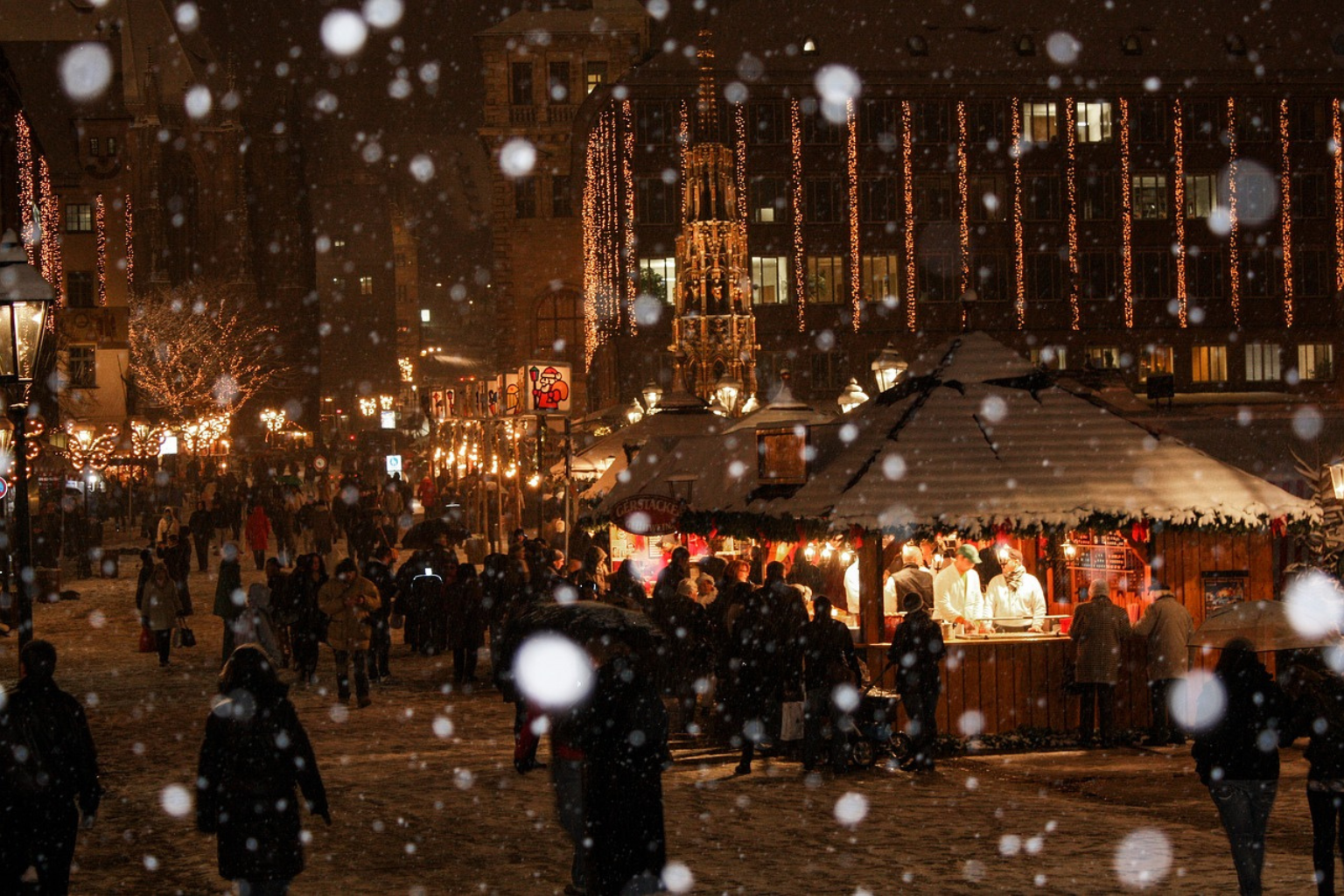 Noche en mercado navidad de Nuremberg, en Alemania, nevando.